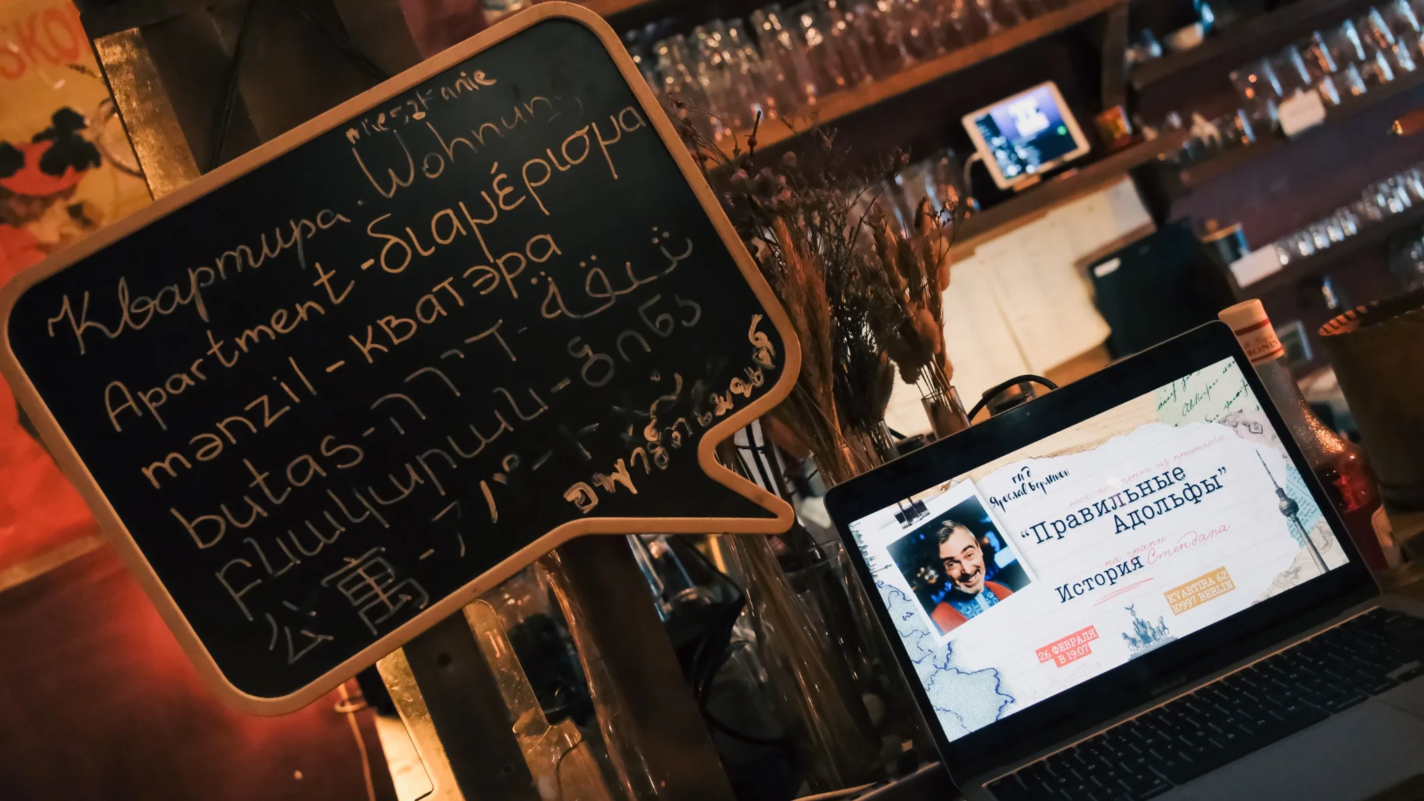 Multilingual welcome board and presentation laptop at a guide event