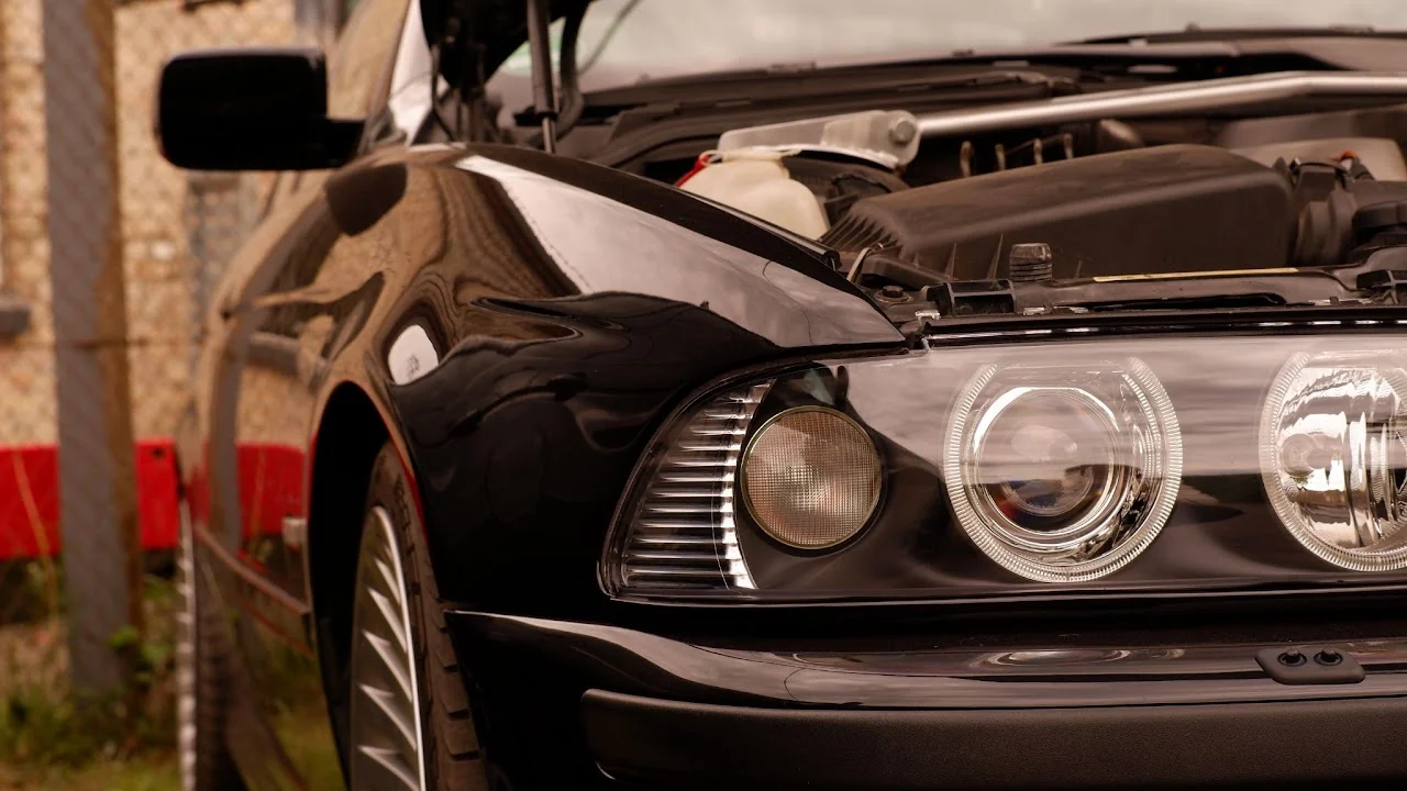 Close view of a black BMW headlight with the hood open