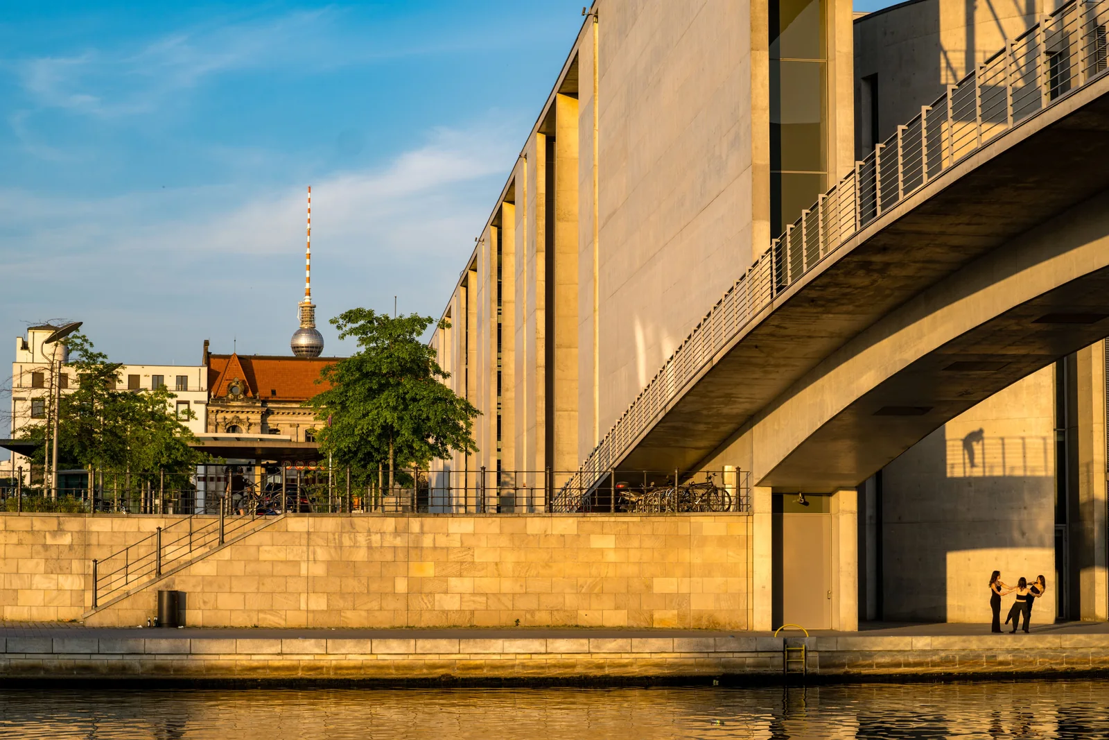 Modern Berlin architecture and a riverside walkway in warm evening light