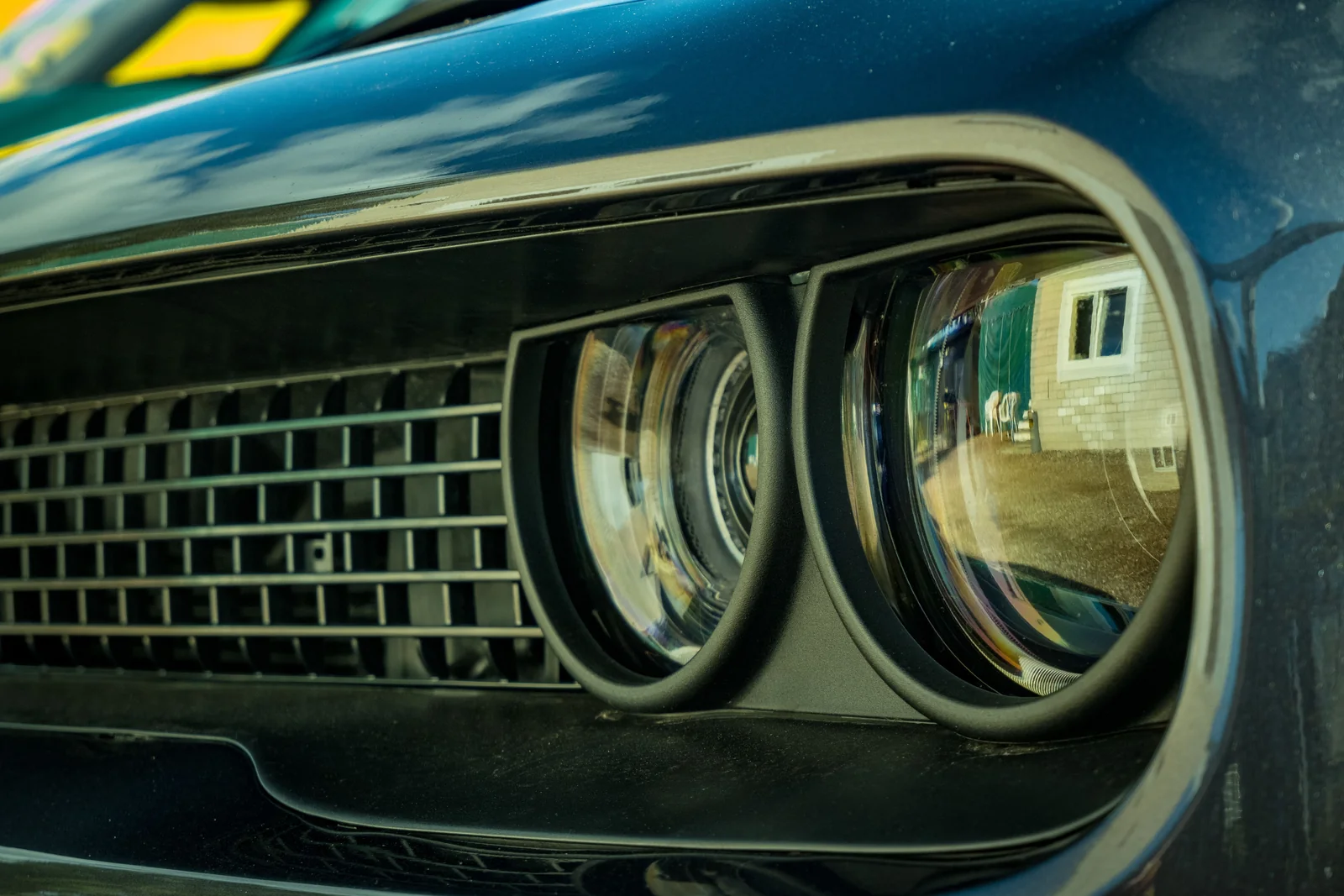 Close-up of a classic car grille and round headlight