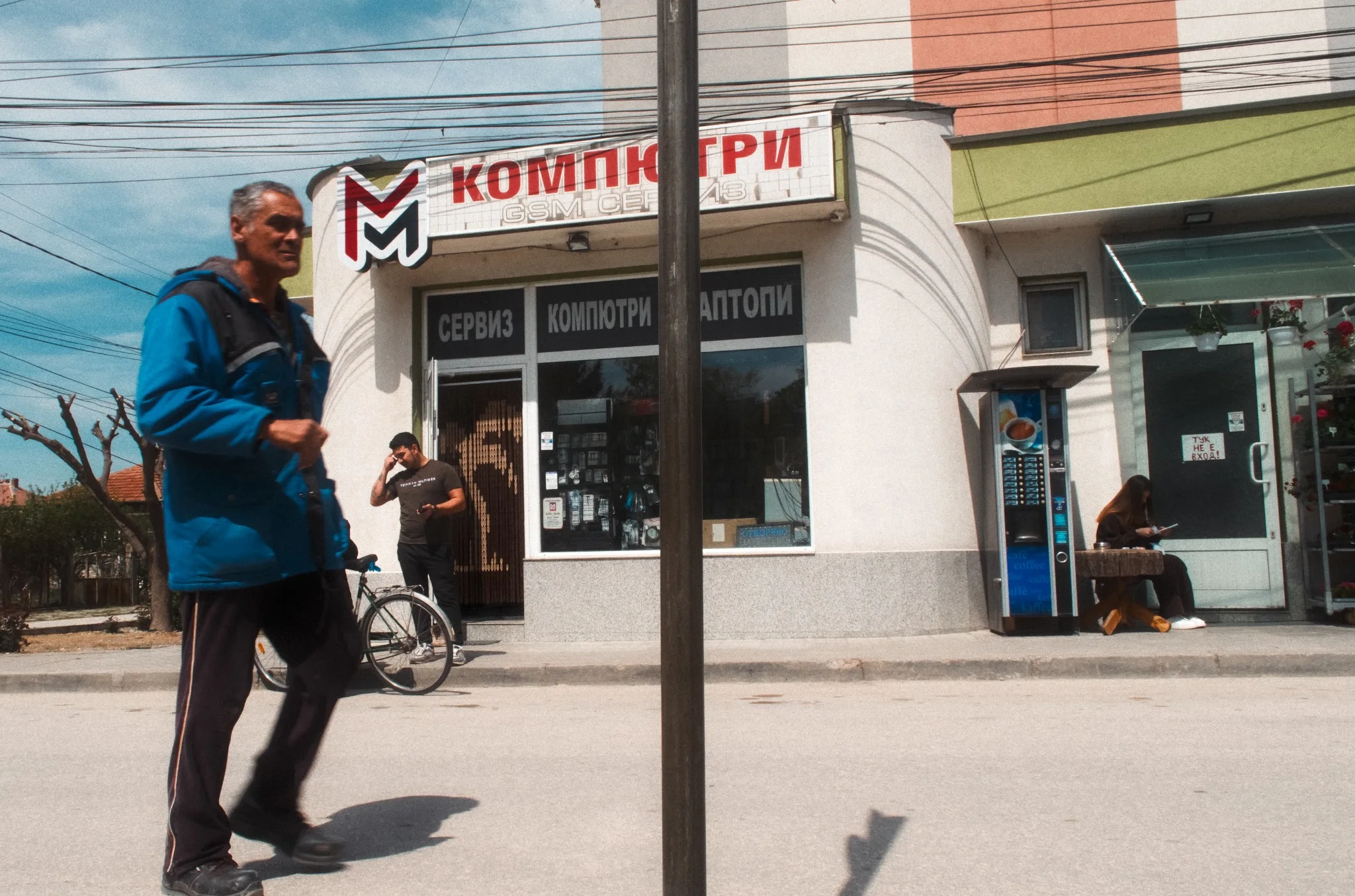 Everyday street scene with pedestrians, storefronts and overhead wires