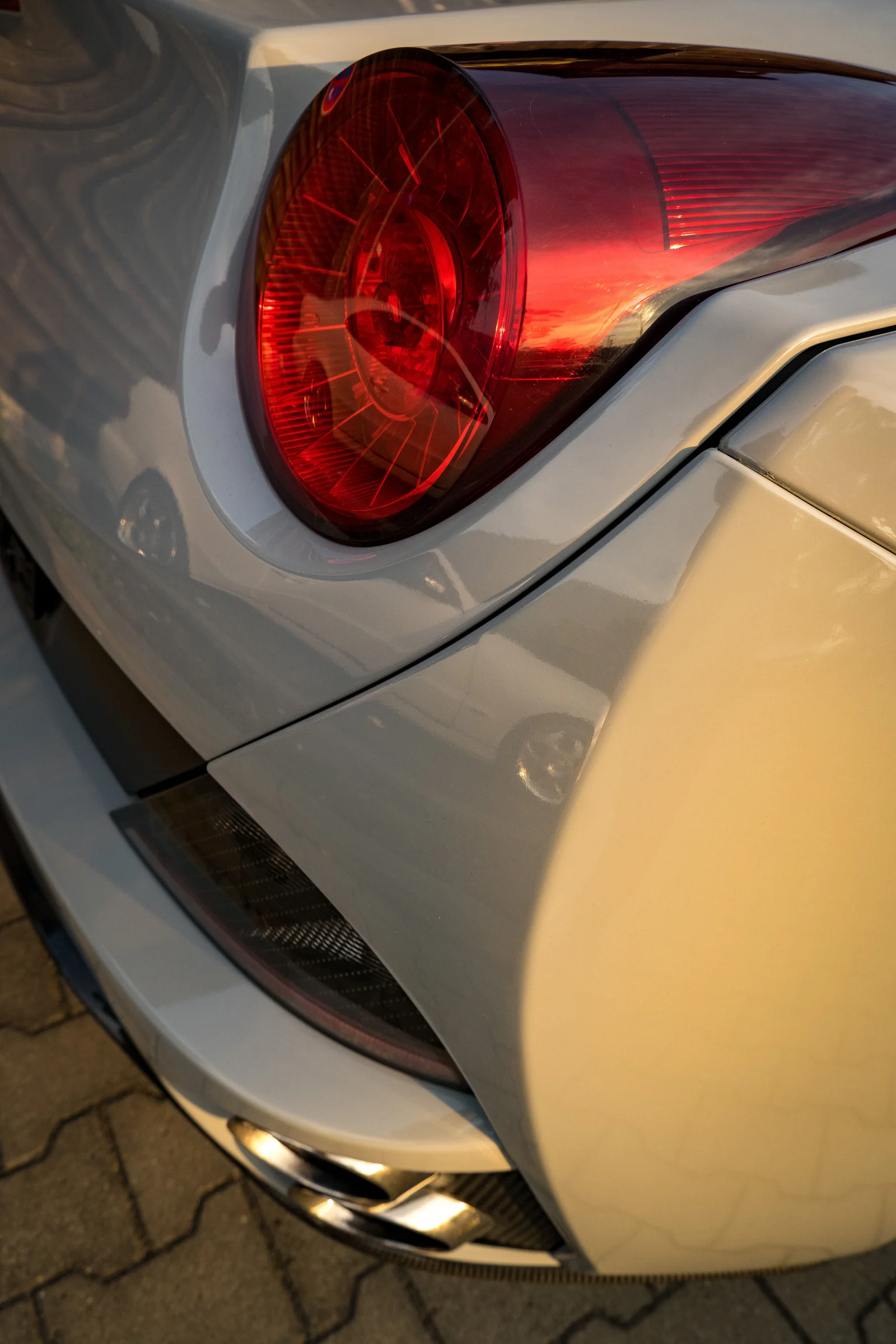 Close-up of a red Ferrari tail light and sculpted bodywork