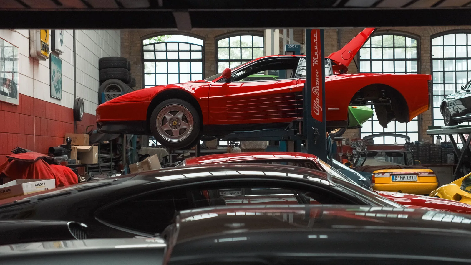 Red classic sports cars displayed in an automotive workshop