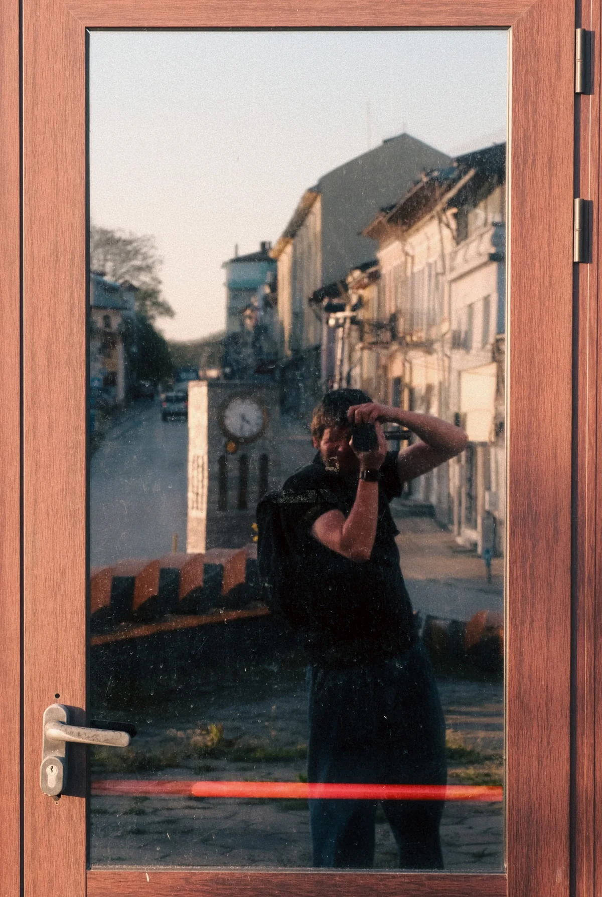 Ivan Chumak photographing his reflection in a glass door in Berlin.