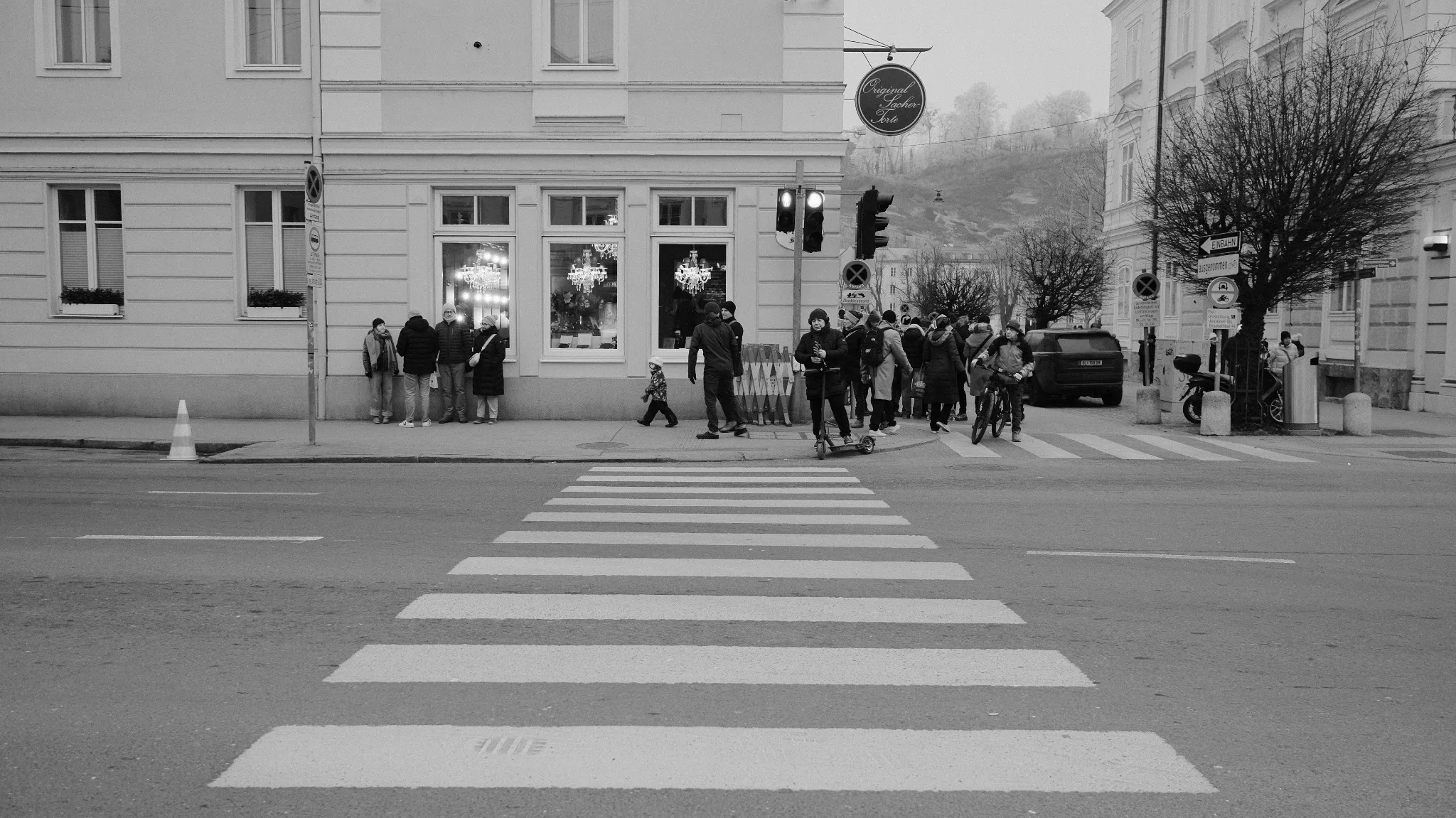 Black-and-white street scene at a zebra crossing in Salzburg on a foggy winter day