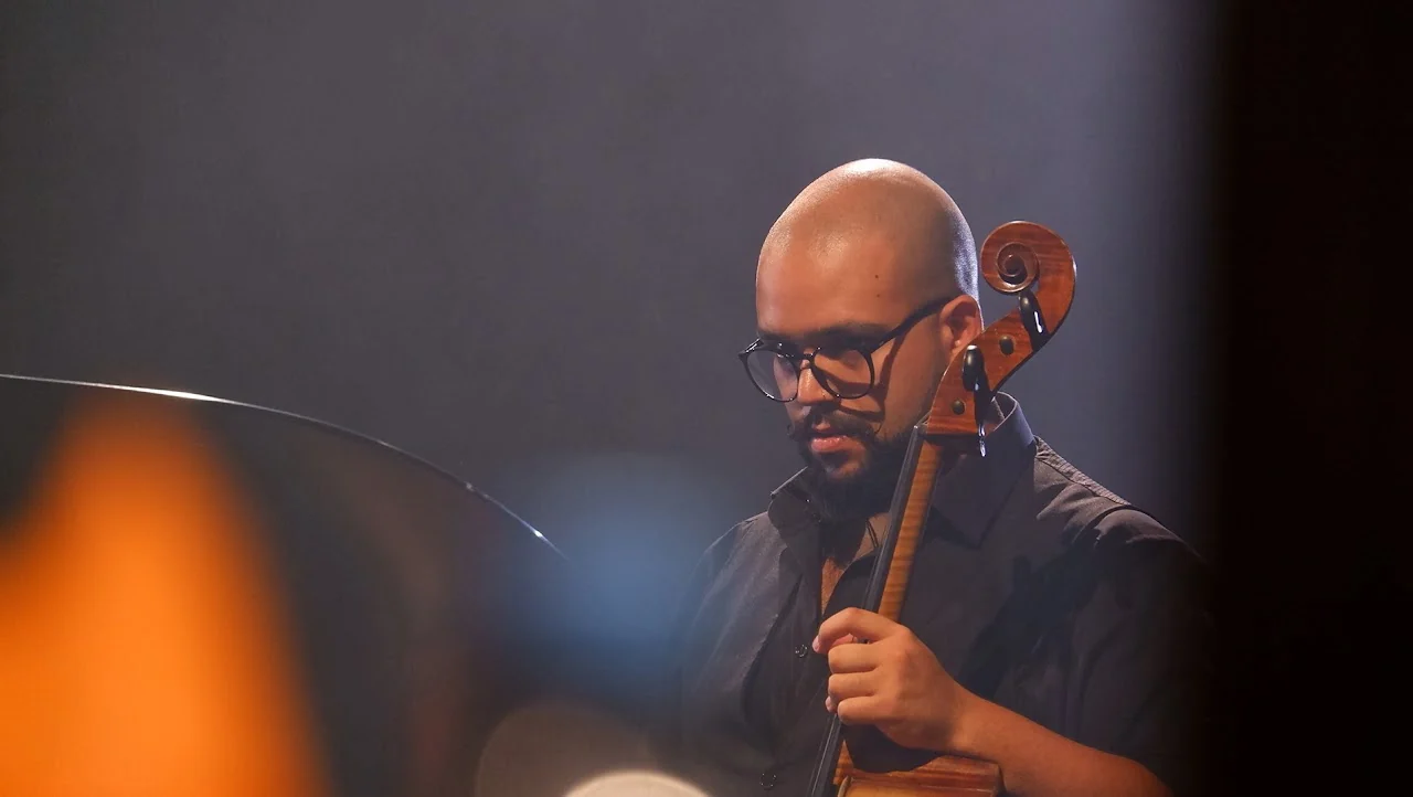 Cellist performing under warm light during a live concert