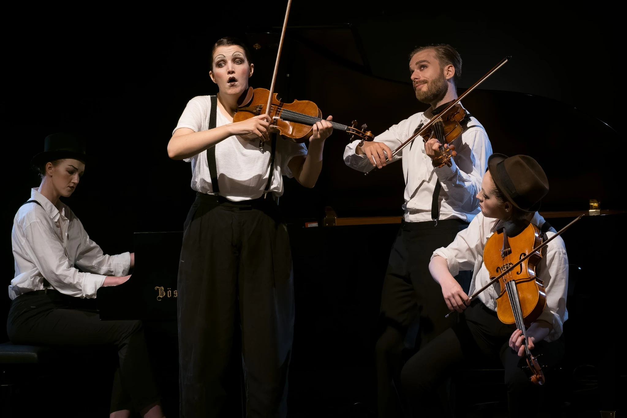 A violinist performing with expressive emotion alongside a chamber ensemble