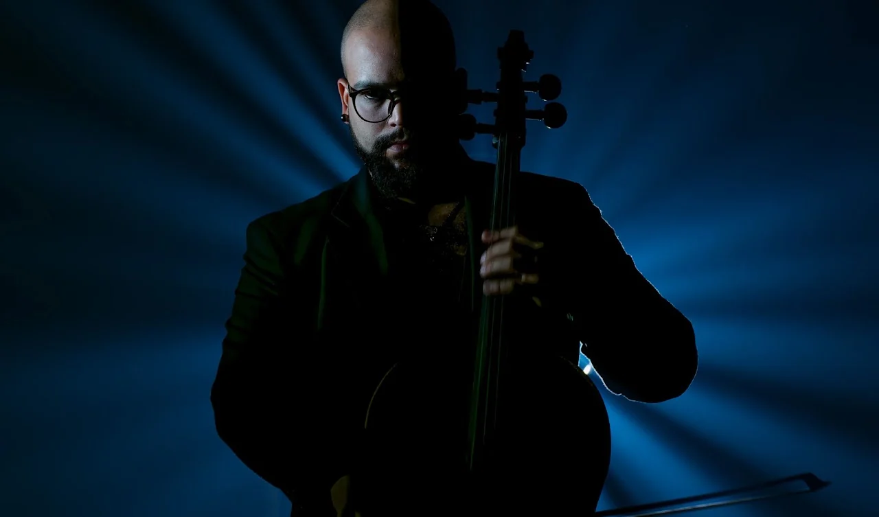 Portrait of a cellist in dramatic blue light